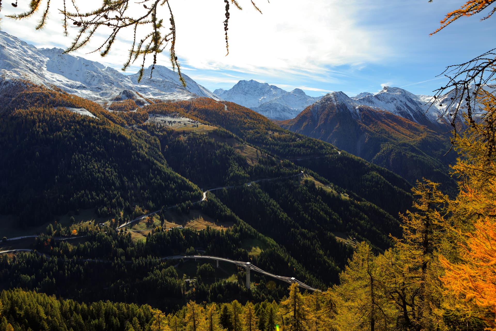 Herbstpanorama des Simplontals mit Strasse, Viadukt und verschneiten Gipfeln