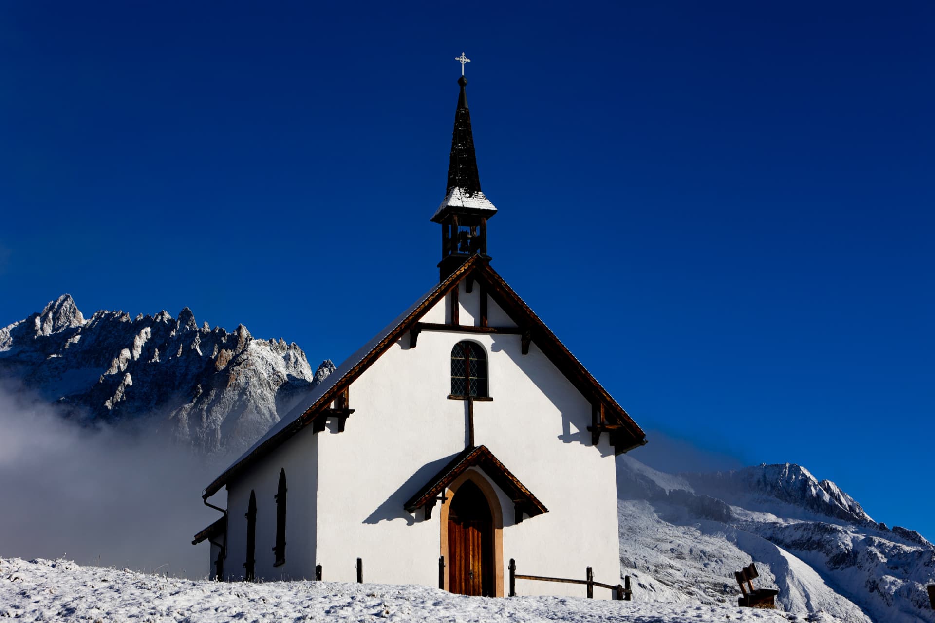 Weisse Kapelle Belalp unter tiefblauem Himmel und verschneiten Gipfeln